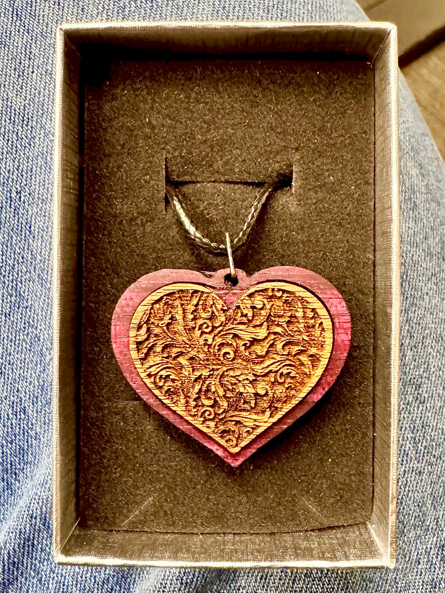 Purpleheart Pendant with Walnut center with an embossed filigree background and hung from a 20" cord.