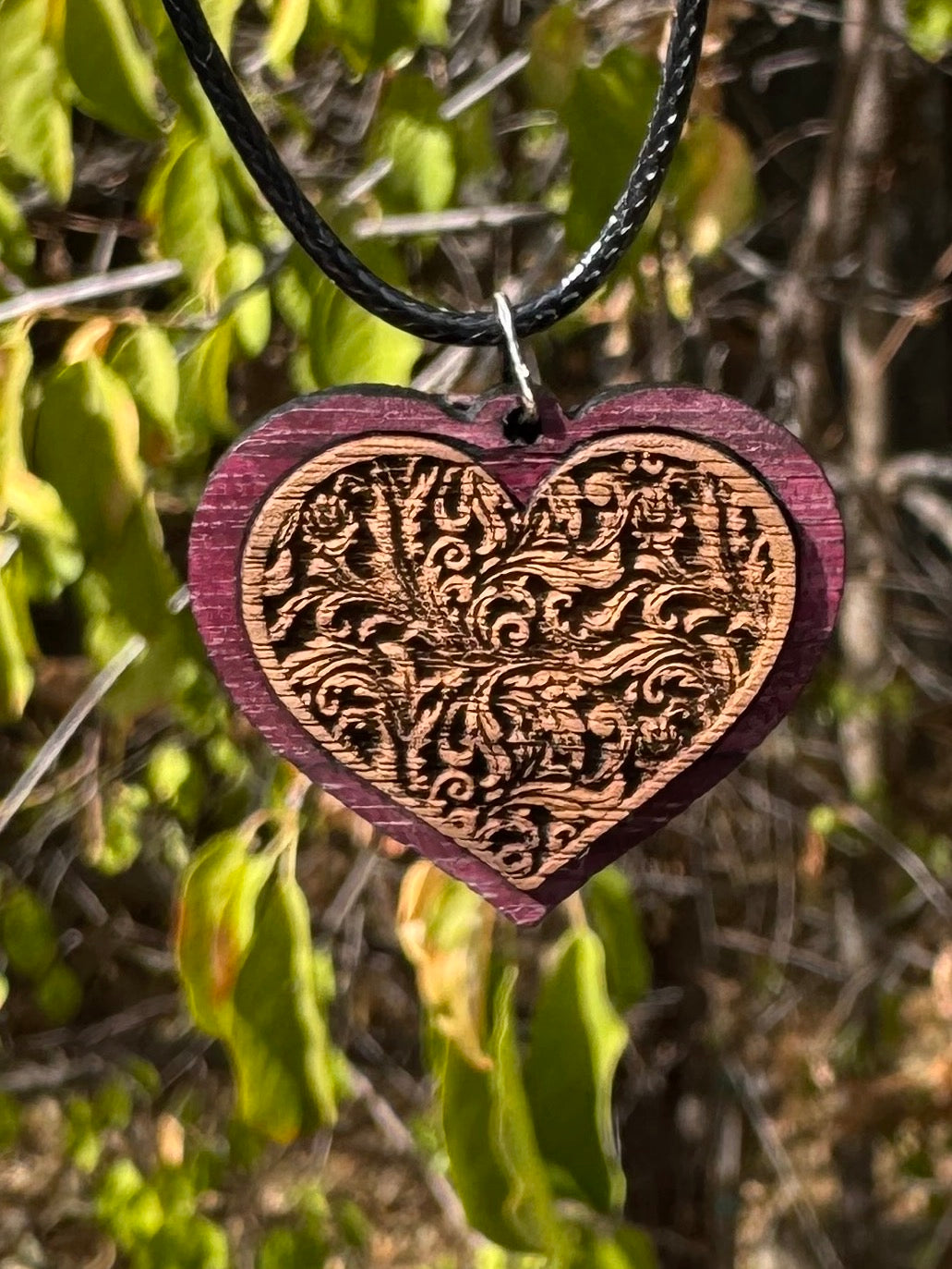 Purpleheart Pendant with Walnut center with an embossed filigree background and hung from a 20" cord.